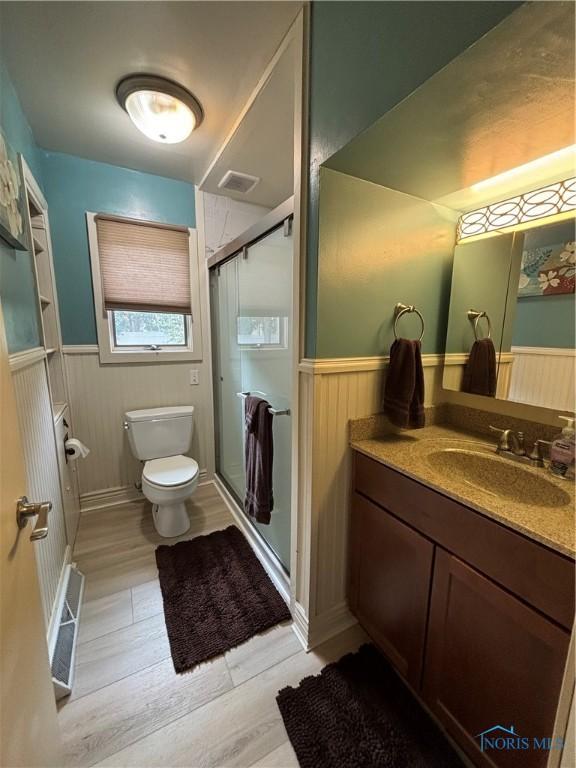 803 W Holland St, Archbold, OH 43502 - full bath with wainscoting, wood finished floors, toilet, vanity, and a shower stall