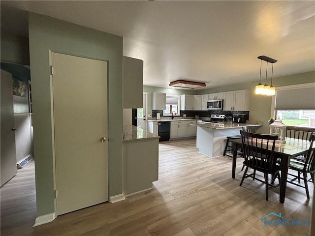 803 W Holland St, Archbold, OH 43502 - kitchen with appliances with stainless steel finishes, a sink, a peninsula, and plenty of natural light
