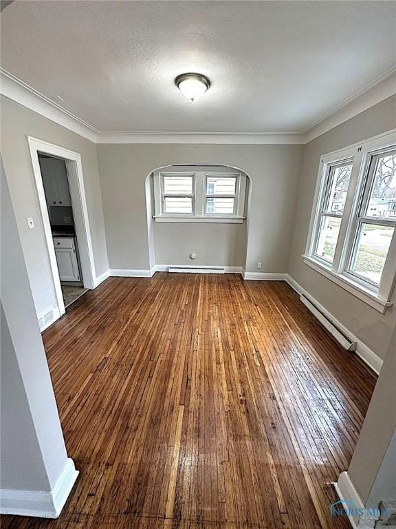 1739 Wyndhurst Rd, Toledo, OH 43607 - unfurnished room featuring baseboard heating, arched walkways, hardwood / wood-style flooring, a baseboard heating unit, and crown molding
