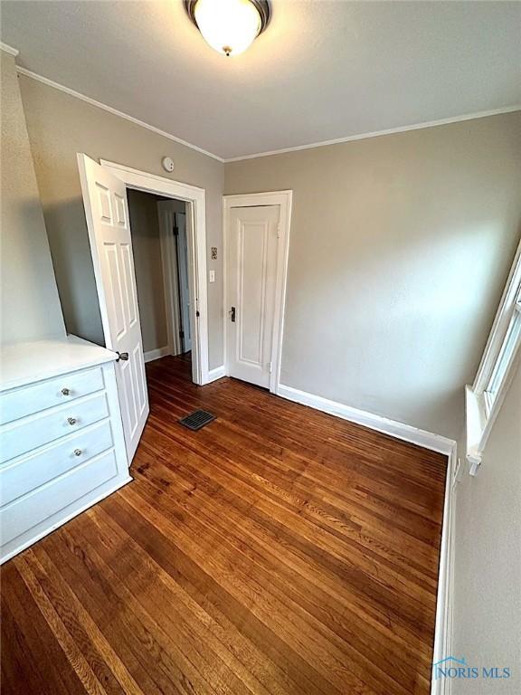 1739 Wyndhurst Rd, Toledo, OH 43607 - unfurnished bedroom with dark wood-style flooring, ornamental molding, and baseboards