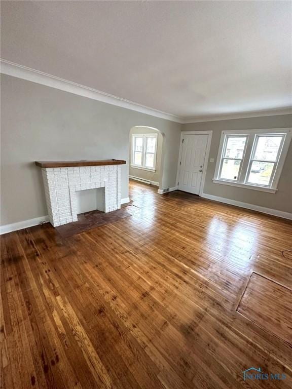 1739 Wyndhurst Rd, Toledo, OH 43607 - unfurnished living room with crown molding, wood finished floors, baseboards, and arched walkways