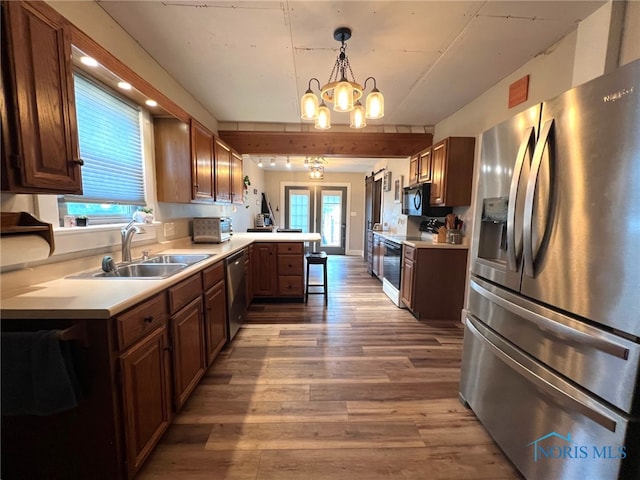 430 W Johnson St, Upper Sandusky, OH 43351 - kitchen with appliances with stainless steel finishes, a peninsula, a sink, light countertops, and wood finished floors