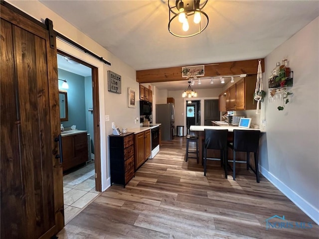 430 W Johnson St, Upper Sandusky, OH 43351 - kitchen with black microwave, freestanding refrigerator, light countertops, and wood finished floors