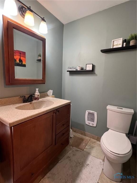 430 W Johnson St, Upper Sandusky, OH 43351 - half bath featuring vanity, toilet, baseboards, stone finish flooring, and heating unit