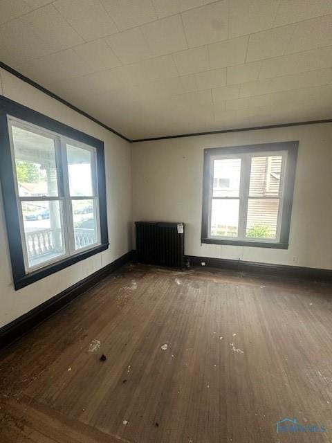 831 Oak St, Toledo, OH 43605 - spare room featuring radiator, wood-type flooring, plenty of natural light, and baseboards