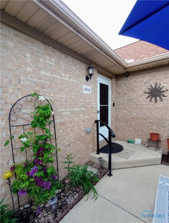 1454 Turnbury Ln, Perrysburg, OH 43551 - entrance to property featuring brick siding, roof with shingles, and a patio