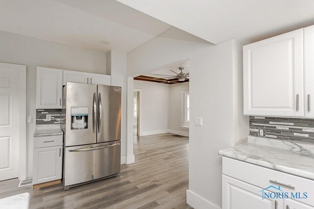 2740 Robinwood Ave, Toledo, OH 43610 - kitchen featuring stainless steel fridge with ice dispenser, ceiling fan, tasteful backsplash, white cabinetry, and light wood-style floors