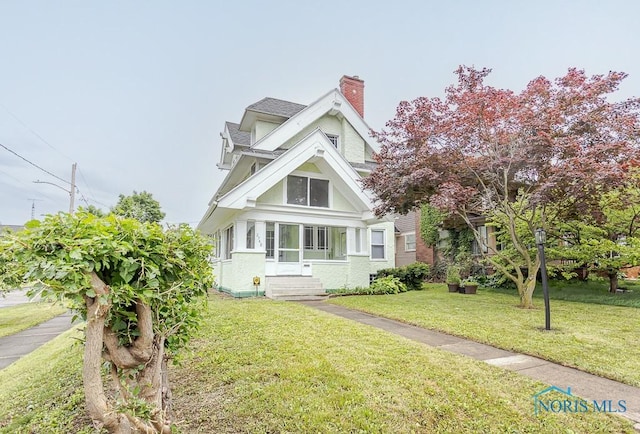 2740 Robinwood Ave, Toledo, OH 43610 - view of front of property with a chimney, a front yard, stucco siding, and entry steps