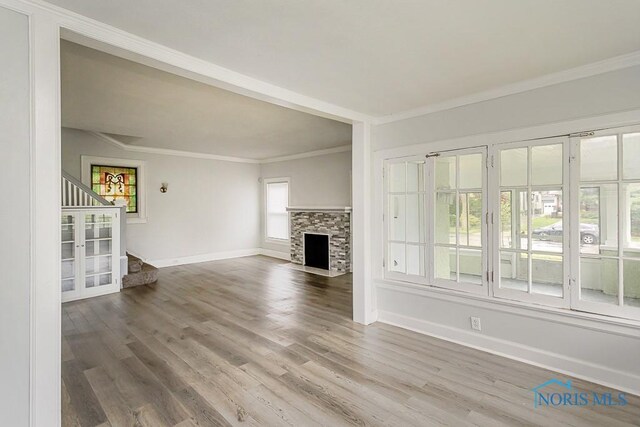 2740 Robinwood Ave, Toledo, OH 43610 - unfurnished living room with stairway, ornamental molding, wood finished floors, and a fireplace with flush hearth