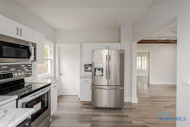 2740 Robinwood Ave, Toledo, OH 43610 - kitchen with appliances with stainless steel finishes, wood finished floors, white cabinetry, and tasteful backsplash
