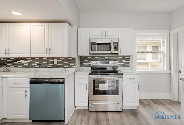 2740 Robinwood Ave, Toledo, OH 43610 - kitchen featuring appliances with stainless steel finishes, decorative backsplash, white cabinetry, light wood-style floors, and recessed lighting
