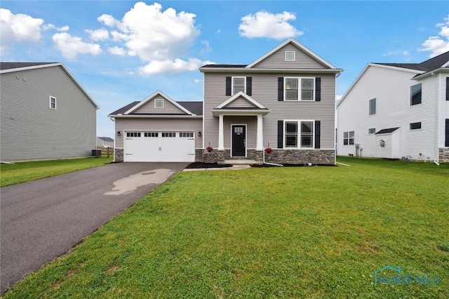 8805 Birchfield Rd, Sylvania, OH 43560 - view of front of house featuring stone siding, asphalt driveway, a garage, and a front lawn