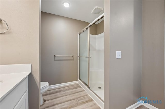 8805 Birchfield Rd, Sylvania, OH 43560 - bathroom with wood finished floors, a shower stall, toilet, vanity, and baseboards