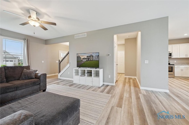 8805 Birchfield Rd, Sylvania, OH 43560 - living room with ceiling fan, light wood-style flooring, stairs, and baseboards