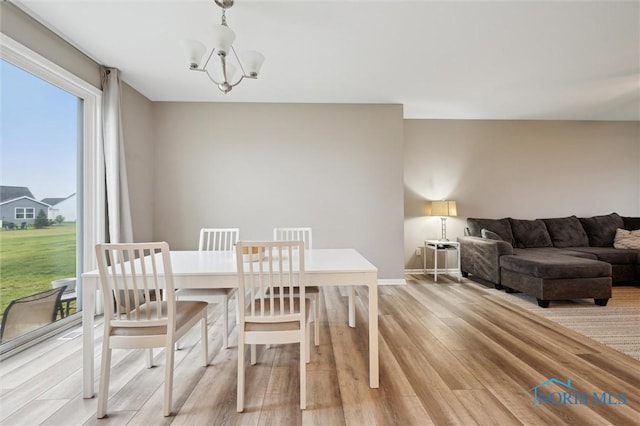 8805 Birchfield Rd, Sylvania, OH 43560 - dining space with light wood-style floors, a chandelier, and baseboards