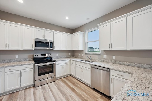 8805 Birchfield Rd, Sylvania, OH 43560 - kitchen featuring stainless steel appliances, a sink, white cabinets, recessed lighting, and light wood-style flooring