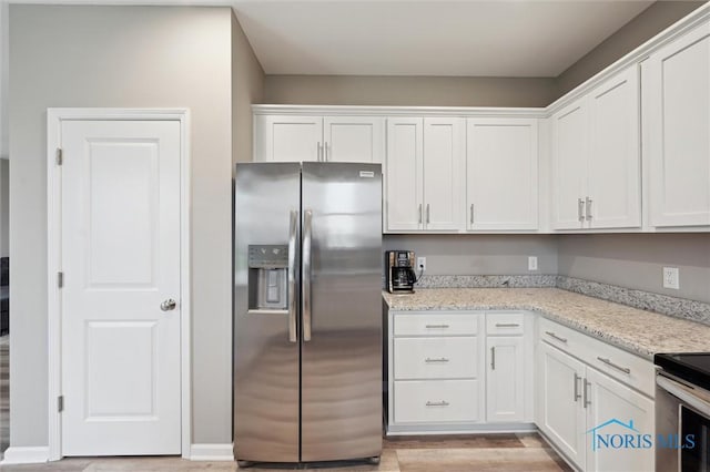 8805 Birchfield Rd, Sylvania, OH 43560 - kitchen featuring stainless steel appliances, white cabinets, light wood finished floors, and light stone counters