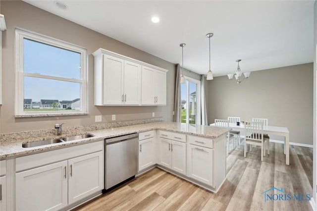 8805 Birchfield Rd, Sylvania, OH 43560 - kitchen with stainless steel dishwasher, a sink, white cabinets, a chandelier, and light wood-style flooring