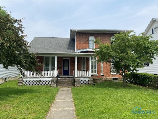 232 N Franklin St, Wauseon, OH 43567 - view of front of home featuring covered porch, a front yard, and brick siding