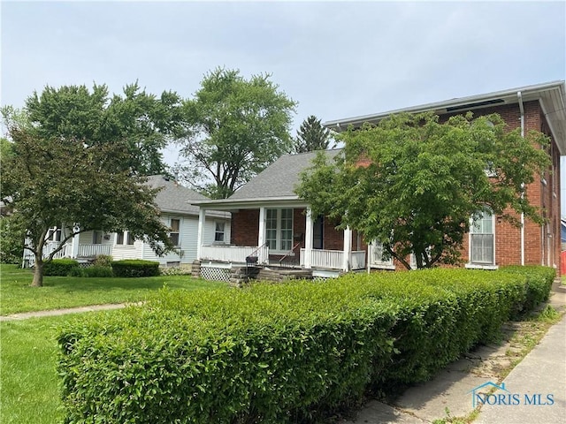 232 N Franklin St, Wauseon, OH 43567 - view of front facade with a porch and brick siding