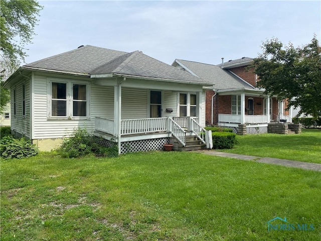 238 N Franklin St, Wauseon, OH 43567 - bungalow-style house with covered porch, a front lawn, and a shingled roof