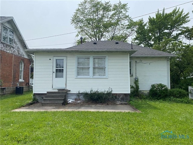 238 N Franklin St, Wauseon, OH 43567 - back of house with entry steps, a yard, central air condition unit, and a shingled roof