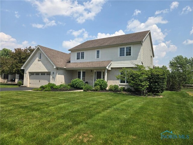 4811 Cabriolet Ln, Maumee, OH 43537 - traditional home with driveway, a front lawn, a garage, and brick siding
