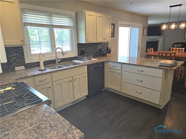 4811 Cabriolet Ln, Maumee, OH 43537 - kitchen with black dishwasher, a peninsula, dark wood finished floors, and decorative backsplash