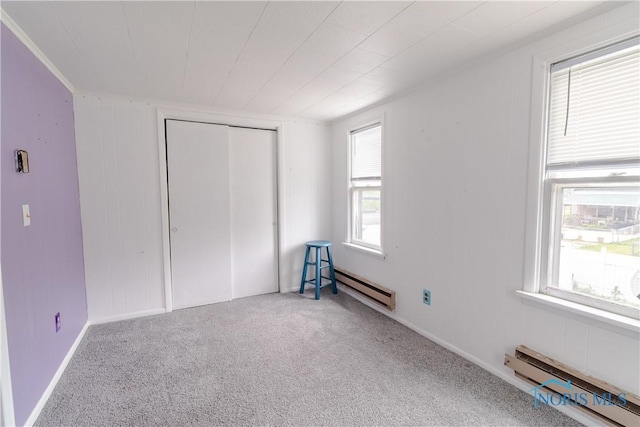 2834 123rd St, Toledo, OH 43611 - unfurnished bedroom with a baseboard heating unit, carpet floors, and a closet