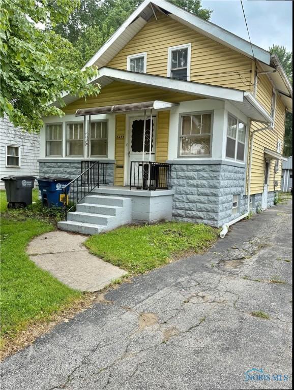 5455 Douglas Rd, Toledo, OH 43613 - bungalow-style home featuring covered porch, stone siding, and asphalt driveway