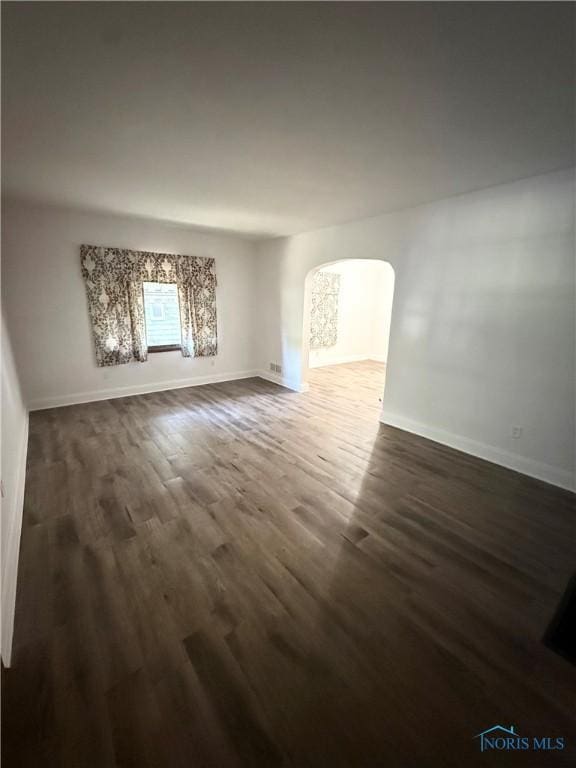 5455 Douglas Rd, Toledo, OH 43613 - unfurnished living room with arched walkways and dark wood-style flooring