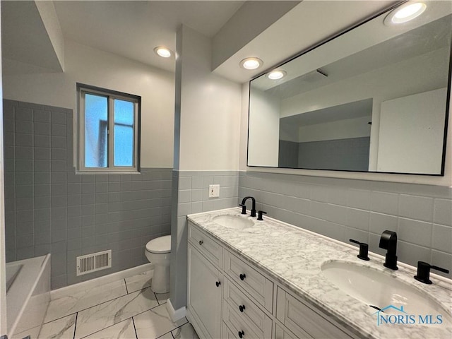 2102 Glen Arbor Dr, Toledo, OH 43614 - full bath with tile walls, toilet, double vanity, a bathtub, and marble look tile flooring