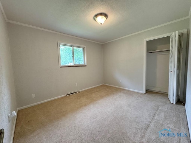 2102 Glen Arbor Dr, Toledo, OH 43614 - unfurnished bedroom with ornamental molding, carpet, baseboards, a closet, and a textured ceiling