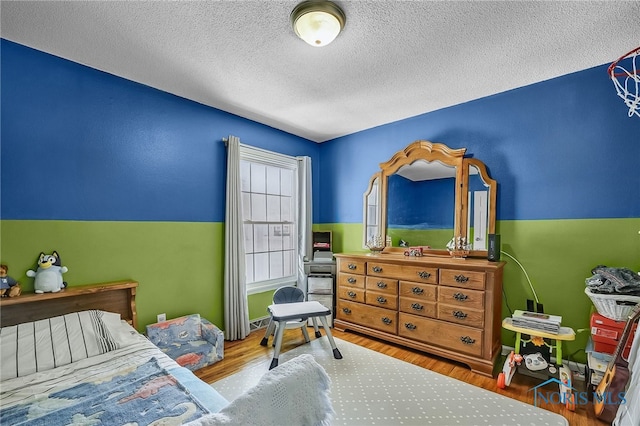 864 Maple Ln, Waterville, OH 43566 - bedroom featuring a textured ceiling and wood finished floors