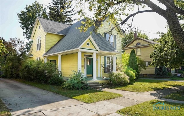 117 3rd St, Findlay, OH 45840 - view of front facade featuring a shingled roof, a front lawn, and a porch
