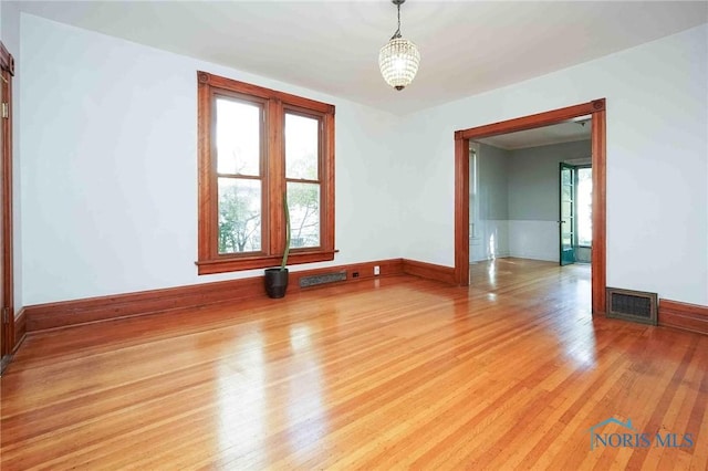 117 3rd St, Findlay, OH 45840 - spare room with light wood-style floors, baseboards, and a chandelier