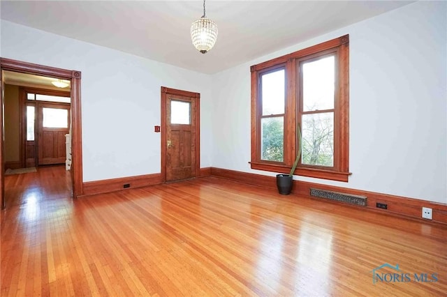 117 3rd St, Findlay, OH 45840 - unfurnished room featuring light wood finished floors, a chandelier, and baseboards