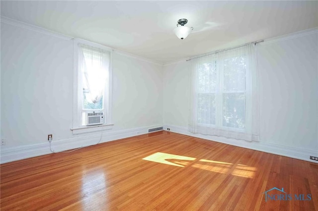 117 3rd St, Findlay, OH 45840 - empty room with cooling unit, wood finished floors, crown molding, and baseboards