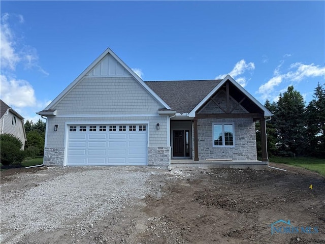 670 Rdg Lake Ct, Perrysburg, OH 43551 - view of front of property with stone siding, a garage, dirt driveway, and roof with shingles