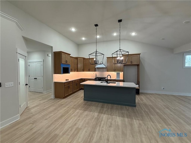 670 Rdg Lake Ct, Perrysburg, OH 43551 - kitchen featuring vaulted ceiling, light countertops, a sink, backsplash, and a center island with sink