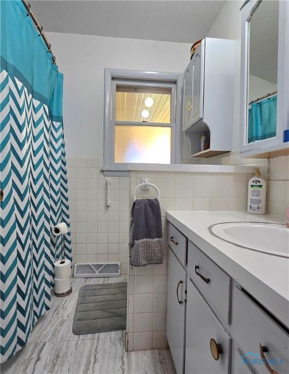1154 Lagrange St, Napoleon, OH 43545 - full bathroom with tile walls, vanity, a shower with shower curtain, and a wainscoted wall