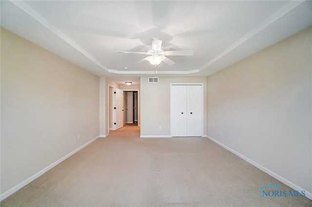 8971 N Park Lake Cir, Sylvania, OH 43560 - unfurnished bedroom featuring a tray ceiling, light carpet, ceiling fan, and a closet
