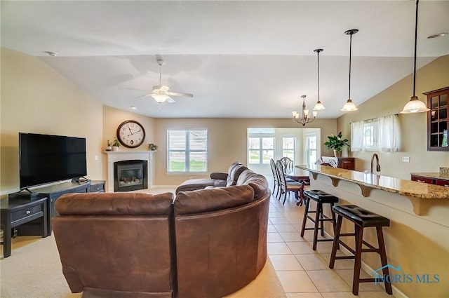 8971 N Park Lake Cir, Sylvania, OH 43560 - living room with lofted ceiling, a chandelier, a ceiling fan, light tile patterned flooring, and a glass covered fireplace