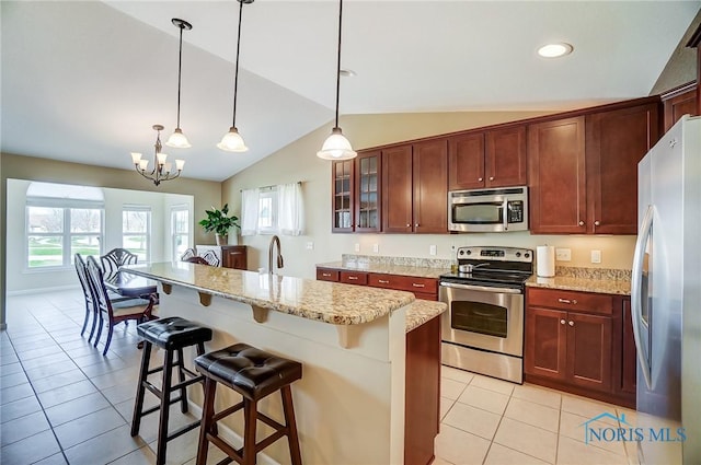 8971 N Park Lake Cir, Sylvania, OH 43560 - kitchen featuring stainless steel appliances, light tile patterned floors, vaulted ceiling, glass insert cabinets, and a kitchen breakfast bar