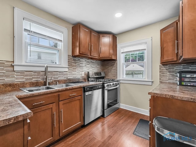 2238 Oak Grove Pl, Toledo, OH 43613 - kitchen with a sink, stainless steel appliances, wood finished floors, baseboards, and brown cabinets