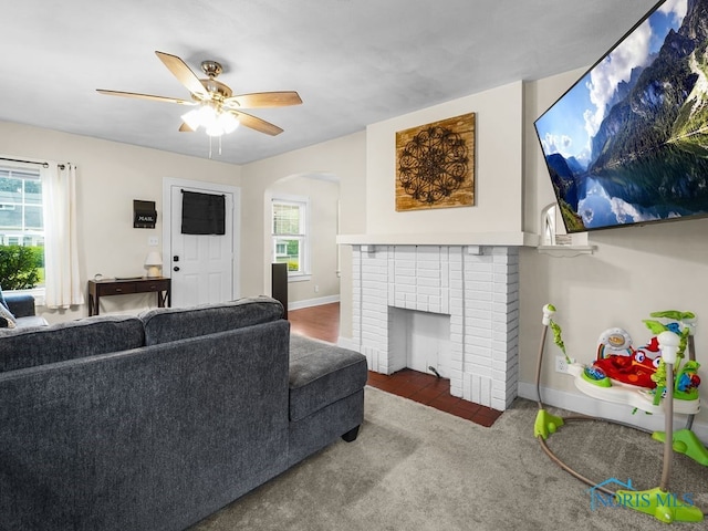 2238 Oak Grove Pl, Toledo, OH 43613 - carpeted living room featuring arched walkways, baseboards, ceiling fan, and a brick fireplace