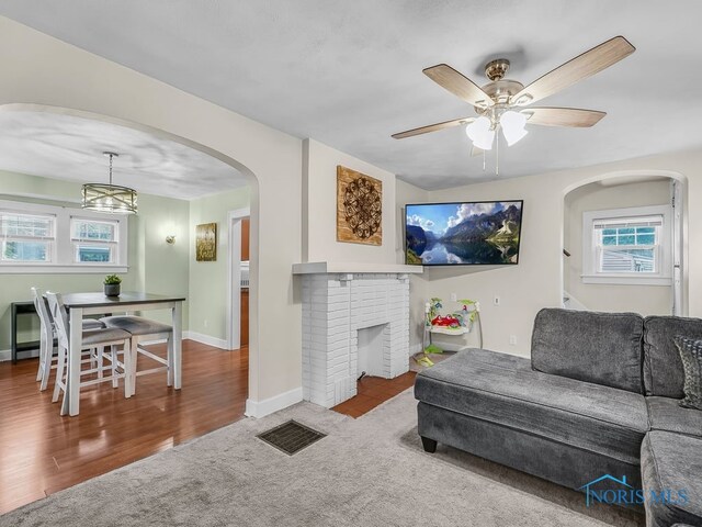 2238 Oak Grove Pl, Toledo, OH 43613 - living room with carpet floors, arched walkways, ceiling fan, baseboards, and a fireplace