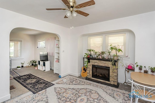 4405 Vermaas Ave, Toledo, OH 43612 - living room with arched walkways, ceiling fan, carpet flooring, and a stone fireplace