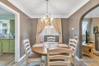 3643 Kershaw Ave, Toledo, OH 43613 - dining area with a chandelier, ornamental molding, arched walkways, wood finished floors, and baseboards