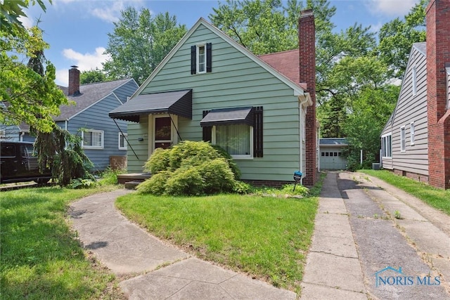 3643 Kershaw Ave, Toledo, OH 43613 - bungalow-style home with a chimney, a front lawn, and a garage